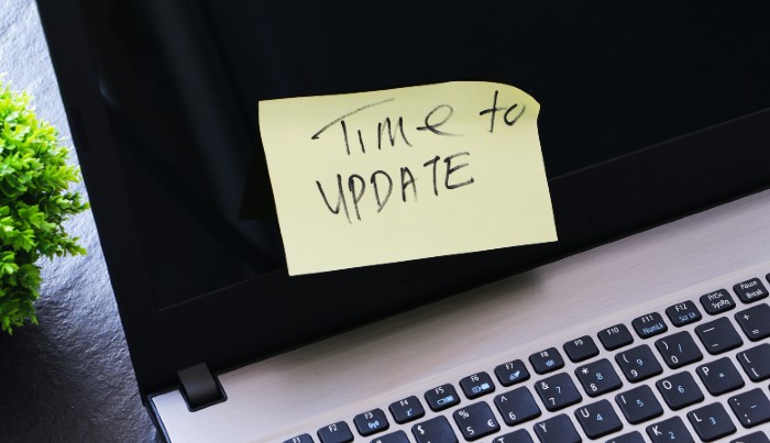 A laptop with a sticky note on it which says 'time to update'