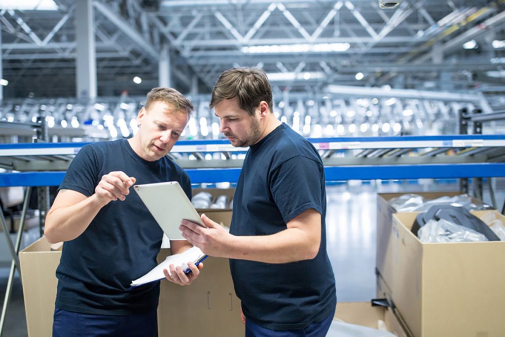 a man training his colleague about their new manufacturing crm