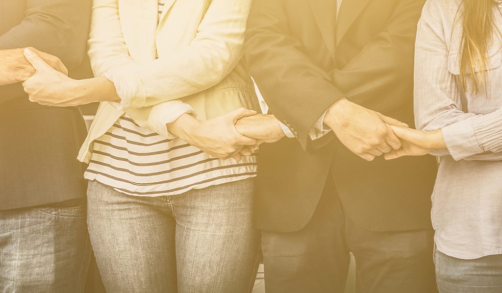 a group of C-level executives of managed service companies holding hands