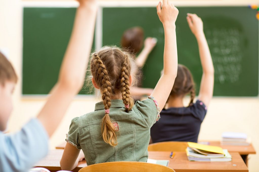 Students raising their hands to answer