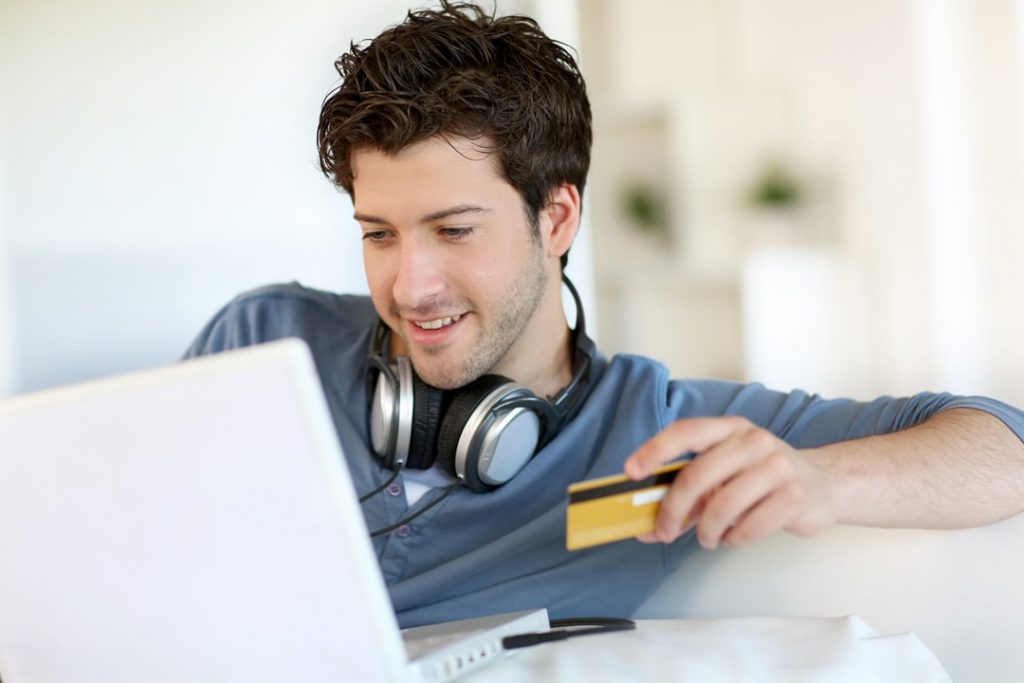 A man holding his laptop and credit card