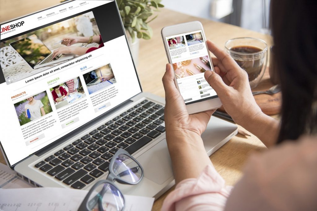 a woman using her mobile phone and laptop